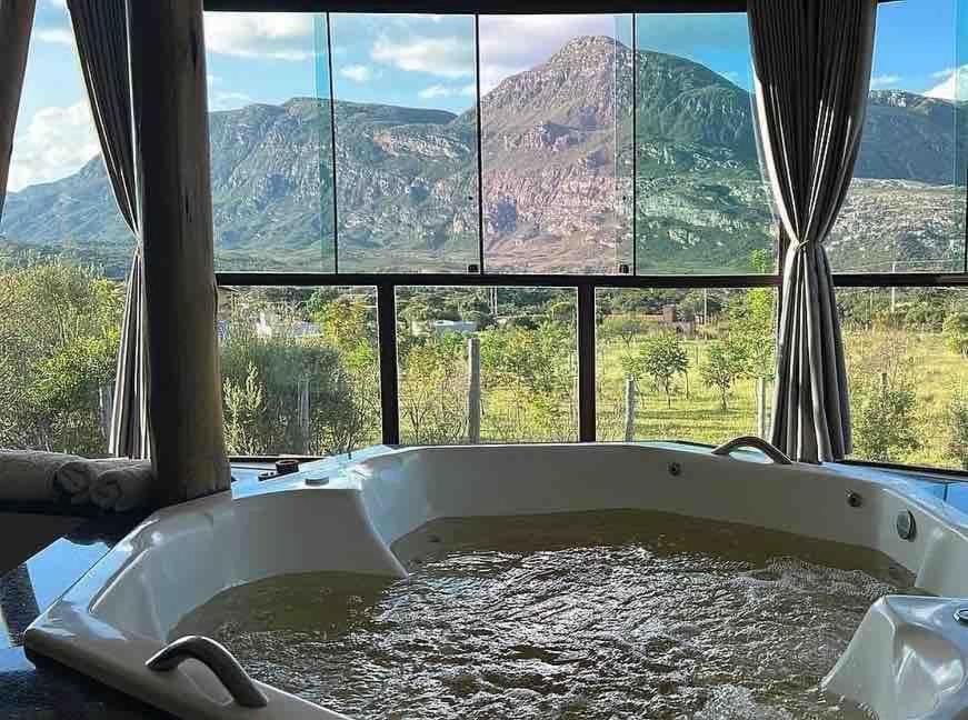 een bad gevuld met water voor een raam bij Casa 422 - Loft Oliveira in Santana do Riacho