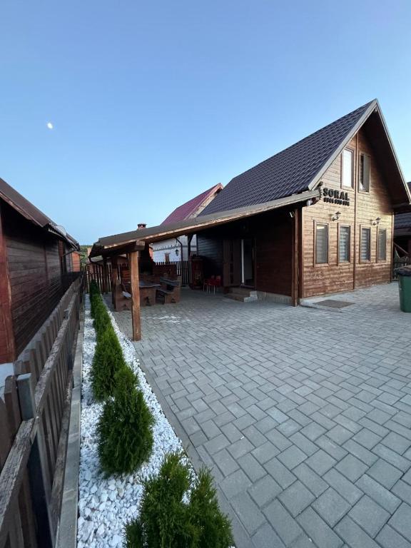 a building with a brick courtyard in front of it at Cabana Soral Baile Figa in Beclean