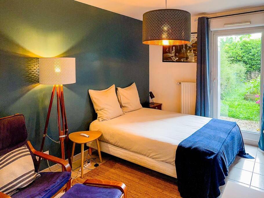 une chambre avec un lit, une chaise et une fenêtre dans l'établissement Appartement T2 avec jardin et parking, à Villeurbanne