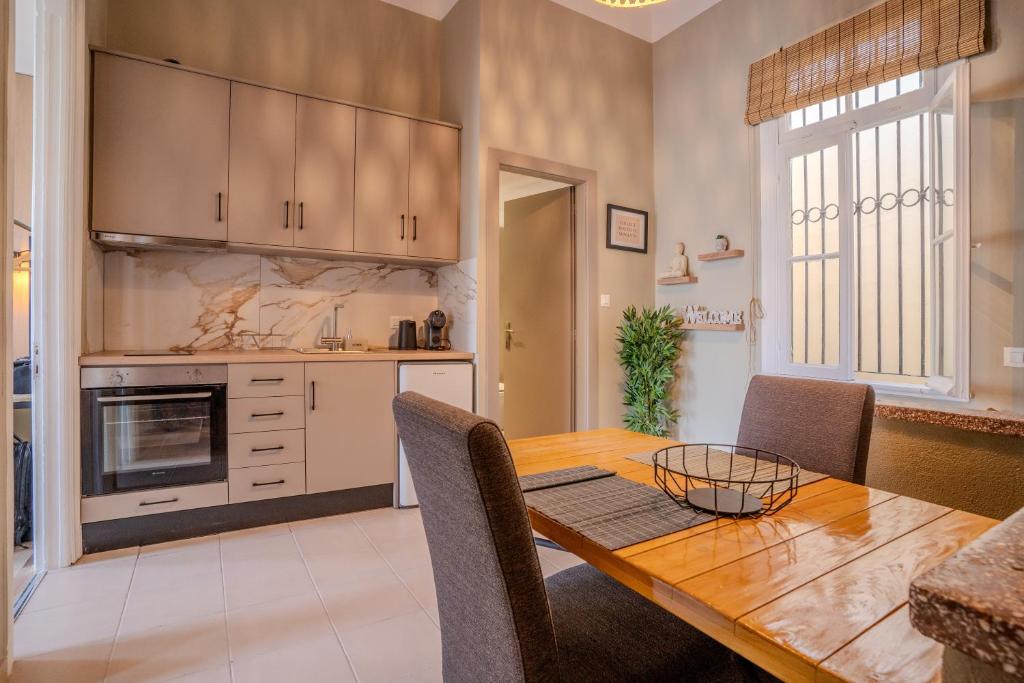 a kitchen and dining room with a wooden table and chairs at City Apartment Home in Chios