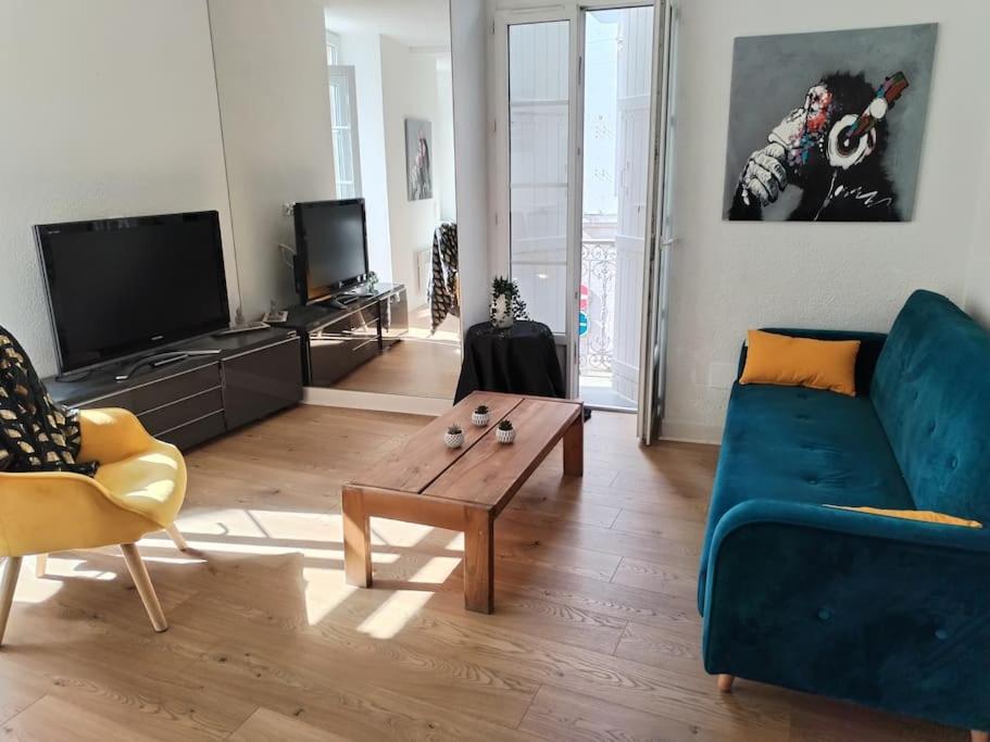 a living room with a blue couch and a coffee table at appartement centre ville in Souillac