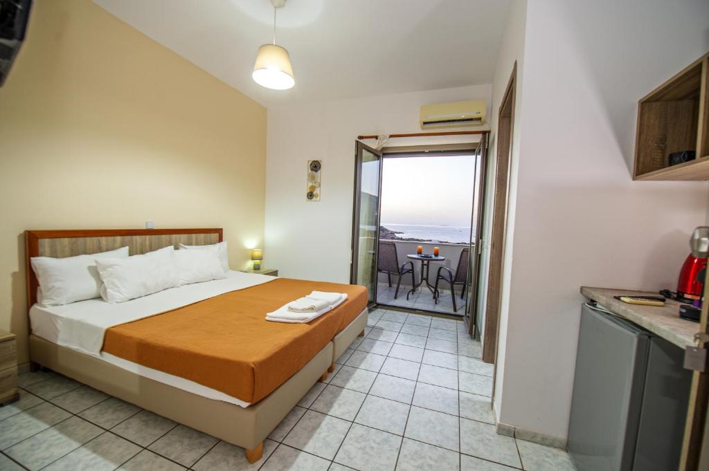 a bedroom with a bed and a balcony with a table at Panorama in Elafonisi