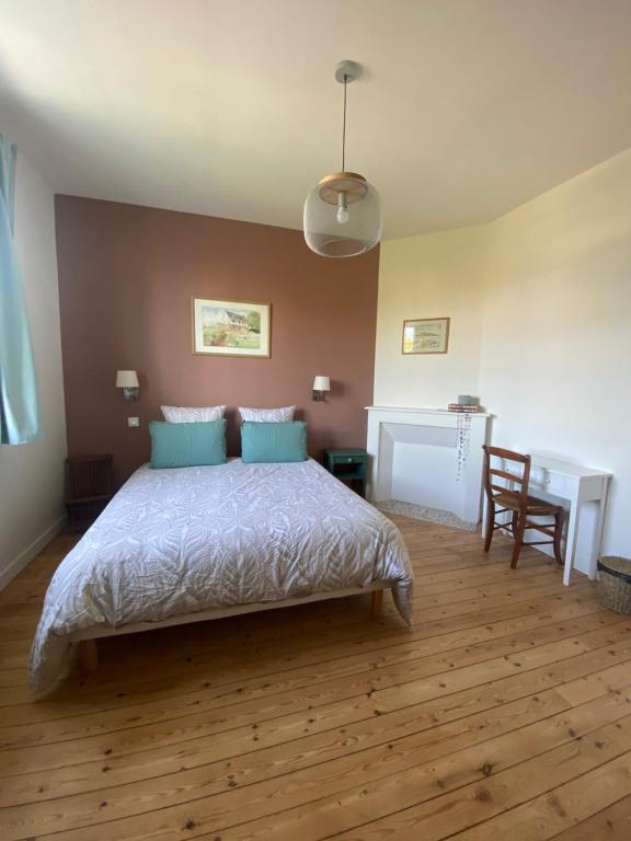 - une chambre avec un lit doté d'oreillers bleus et d'un bureau dans l'établissement La Hacienda Rosita, à Saint-Jouan-des-Guérets