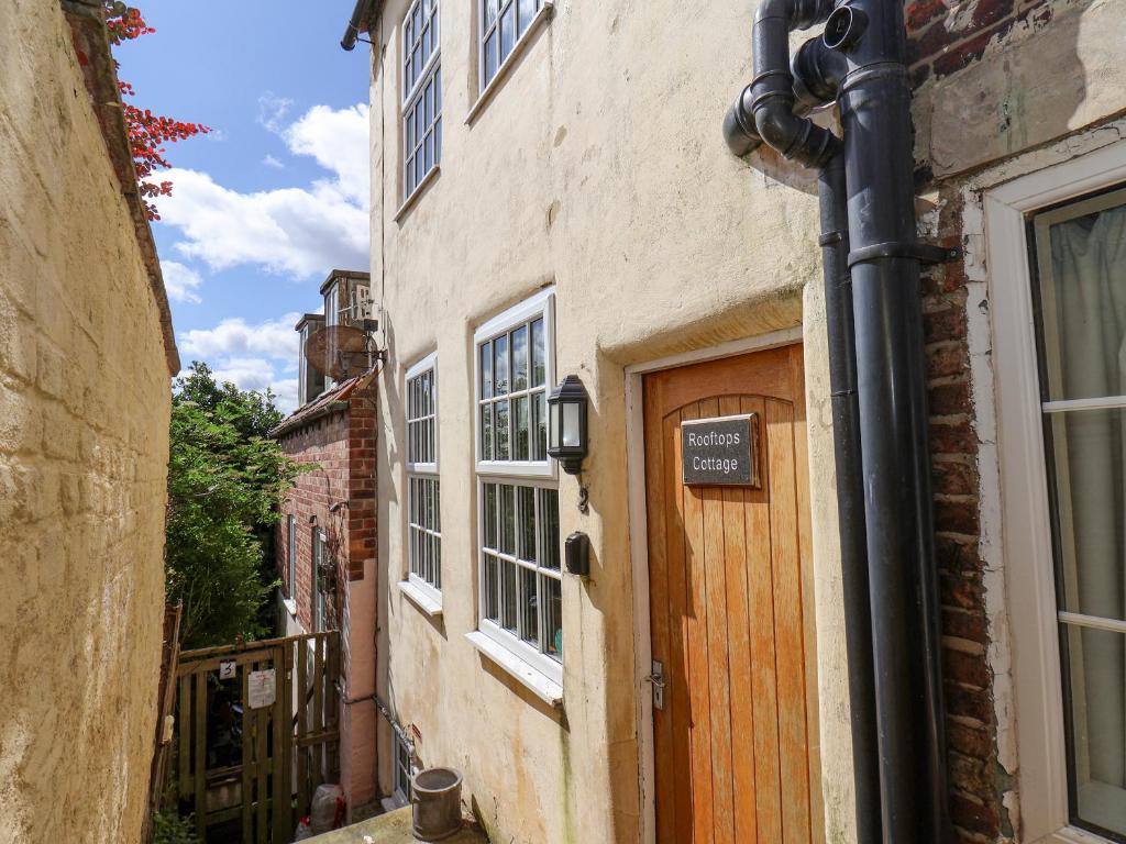 a building with a wooden door on a street at Rooftops Cottage in Whitby