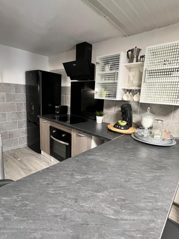 une cuisine avec des appareils noirs et un comptoir dans l'établissement Villa cosy bleue, à Gruissan