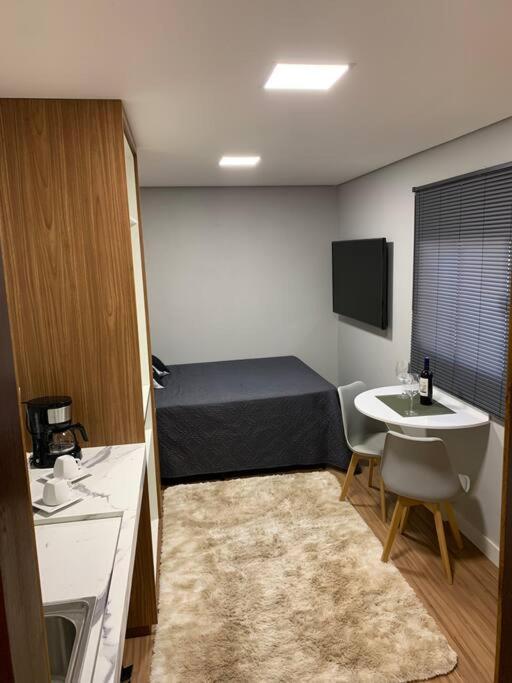 a small room with a bed and a sink at Microcasa na cobertura in Santa Teresa