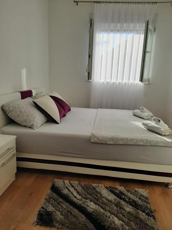 a bedroom with a large bed with a window at Apartmani Pantovic - Apartman 1 in Trebinje