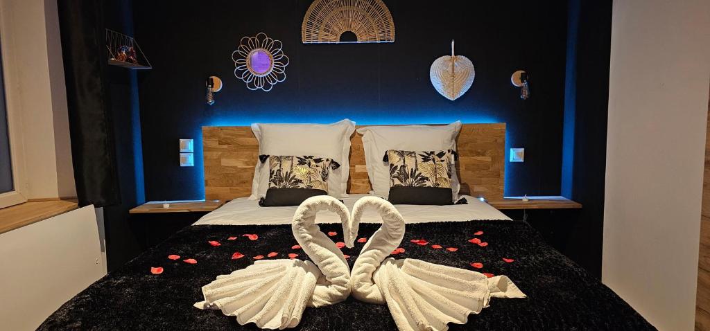a bedroom with a bed with two white wedding rings at Le Clos Maldier - Gîte Les Ecureuils in Laon