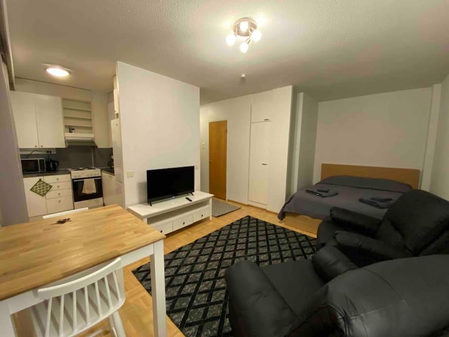 a living room with a couch and a table and a kitchen at Saunallinen yksiö keskustassa in Pieksamaki