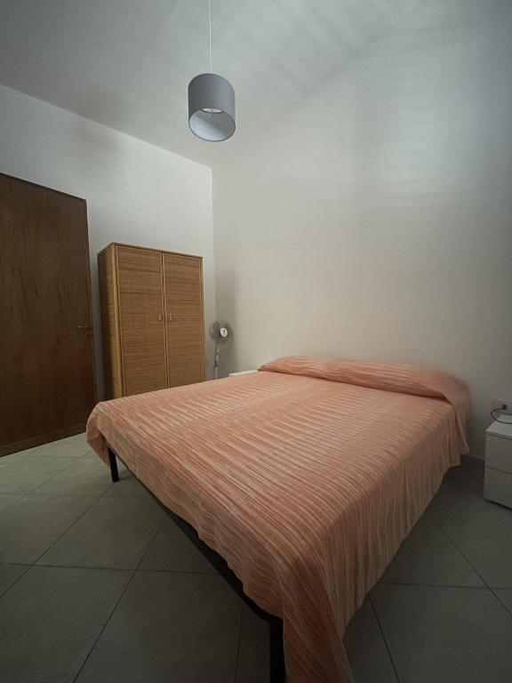 a bedroom with a bed with an orange blanket at Appartamento a 10 metri dal mare, Porto Cesareo in Porto Cesareo