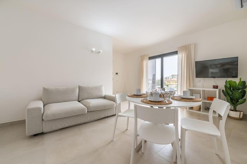 a living room with a couch and a table and chairs at Holiday Camelia in Pirri