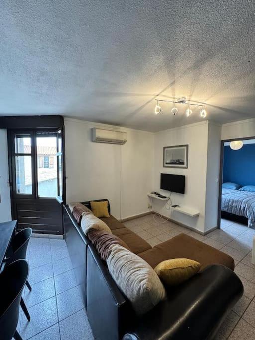 un salon avec un canapé et un lit dans l'établissement Cœur du Village - 4 Pers - Clim, à Gruissan