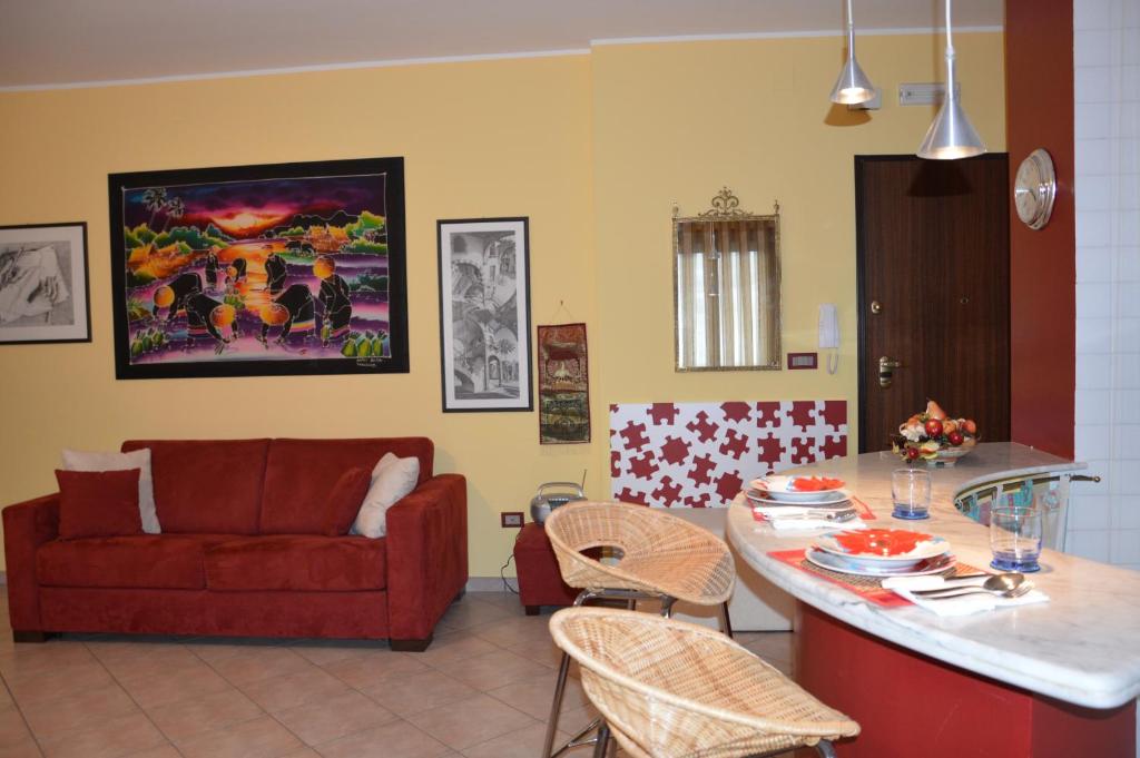 salon z czerwoną kanapą i kuchnią w obiekcie Casa Dei Puzzle w mieście Matera