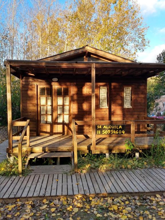 a log cabin with a bench on a deck at Cabañas Pa ke mas in Punta Indio