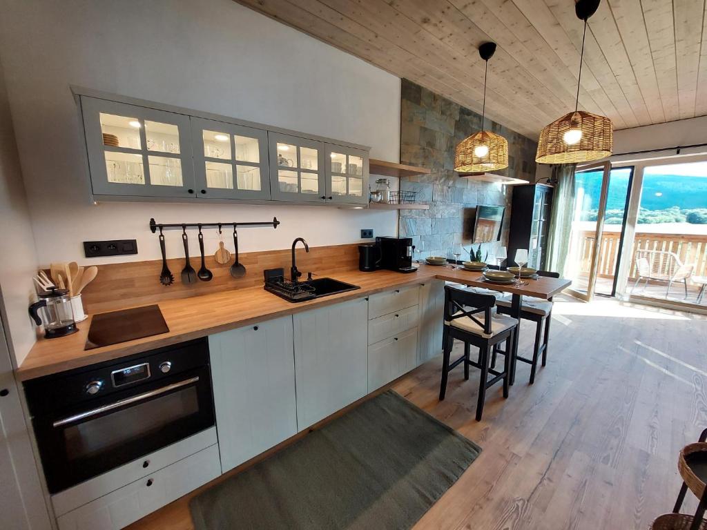a kitchen with white cabinets and a wooden counter top at Apartmán H3 Hrabušice in Hrabušice