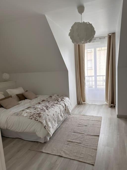 une chambre blanche avec un lit et une grande fenêtre dans l'établissement Charmant T2 Meaux-gare proche Disney-Paris, à Meaux