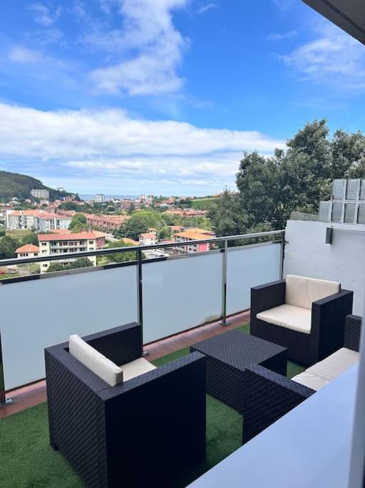 a balcony with two chairs and a table and a view at Apartamento Gaztelugatxe in Bakio