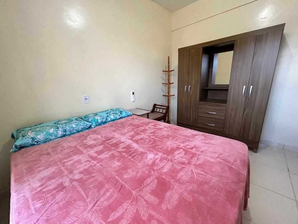 ein Schlafzimmer mit einem rosa Bett und einem Schrank in der Unterkunft Apart-Norte Flat Belém Aeroporto in Belém