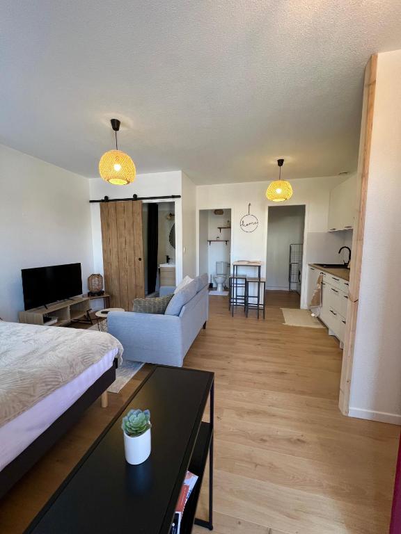 une grande chambre avec un lit et un salon dans l'établissement Studio Le petit Larros, à Gujan-Mestras