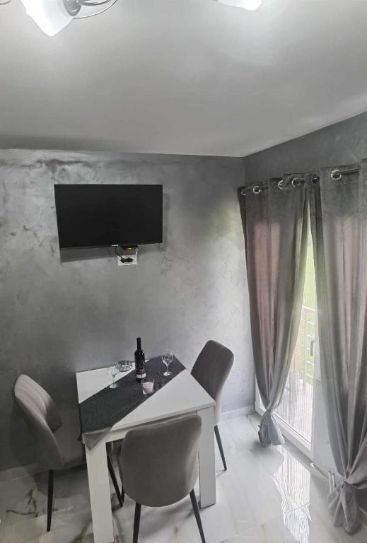 a dining room with a table and chairs and a television at Apartmani Račanka in Bajina Bašta