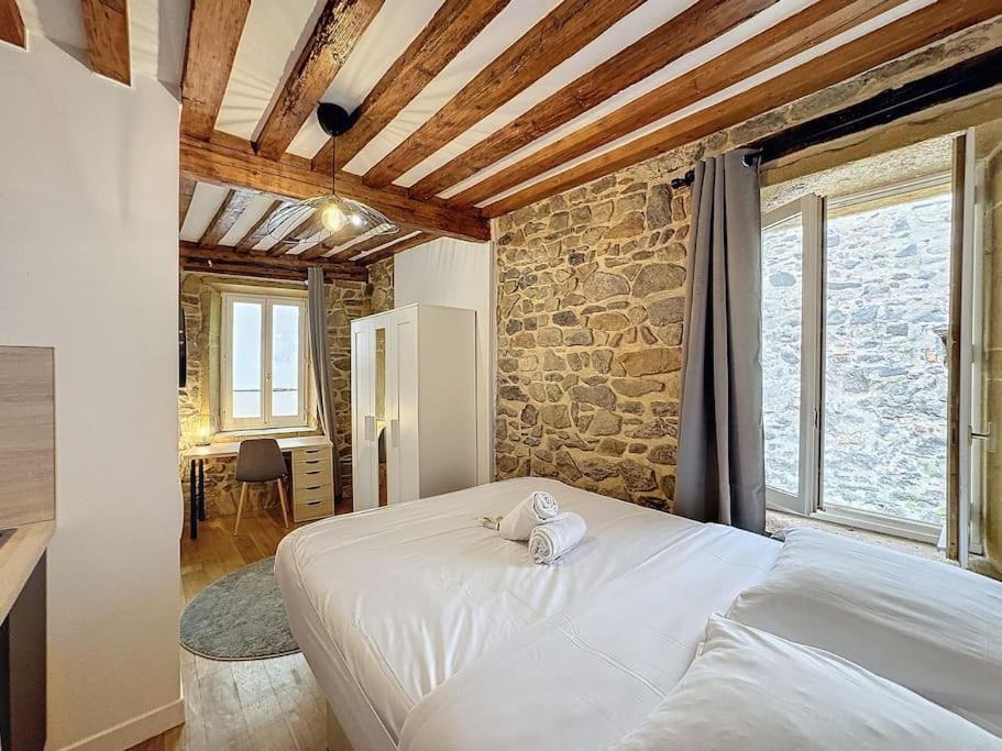 - une chambre avec un lit blanc et un mur en pierre dans l'établissement My home st barthelemy 1, à Lyon