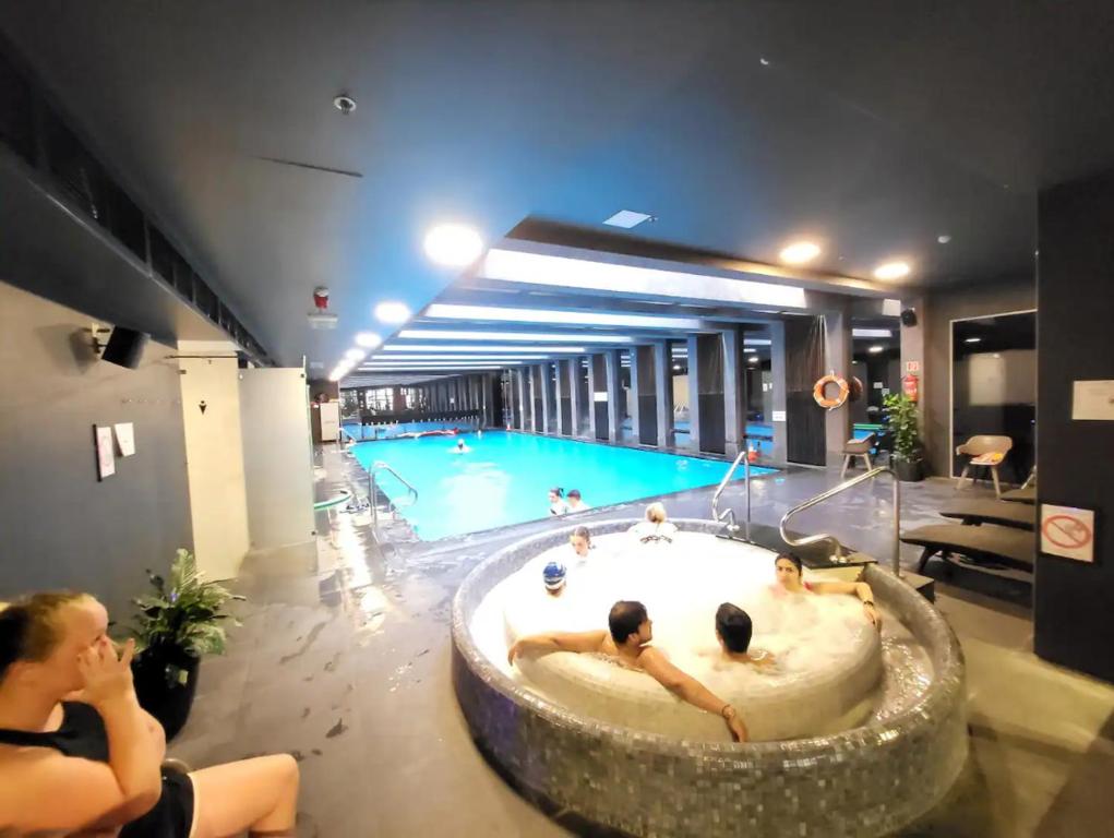 a swimming pool with a tub in the middle of a building at City Center Wellness Suites - POOL-GYM-PARKING in Budapest