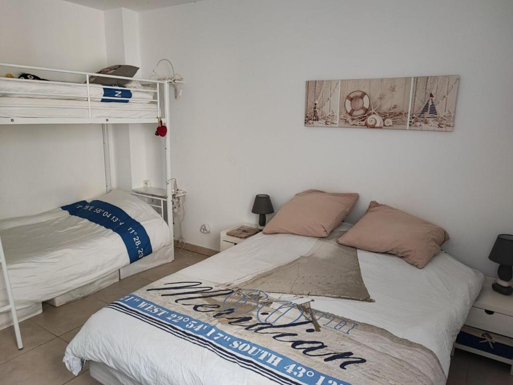 une chambre avec deux lits superposés dans une pièce dans l'établissement Location mer les sablettes chez Huguette, à La Seyne-sur-Mer