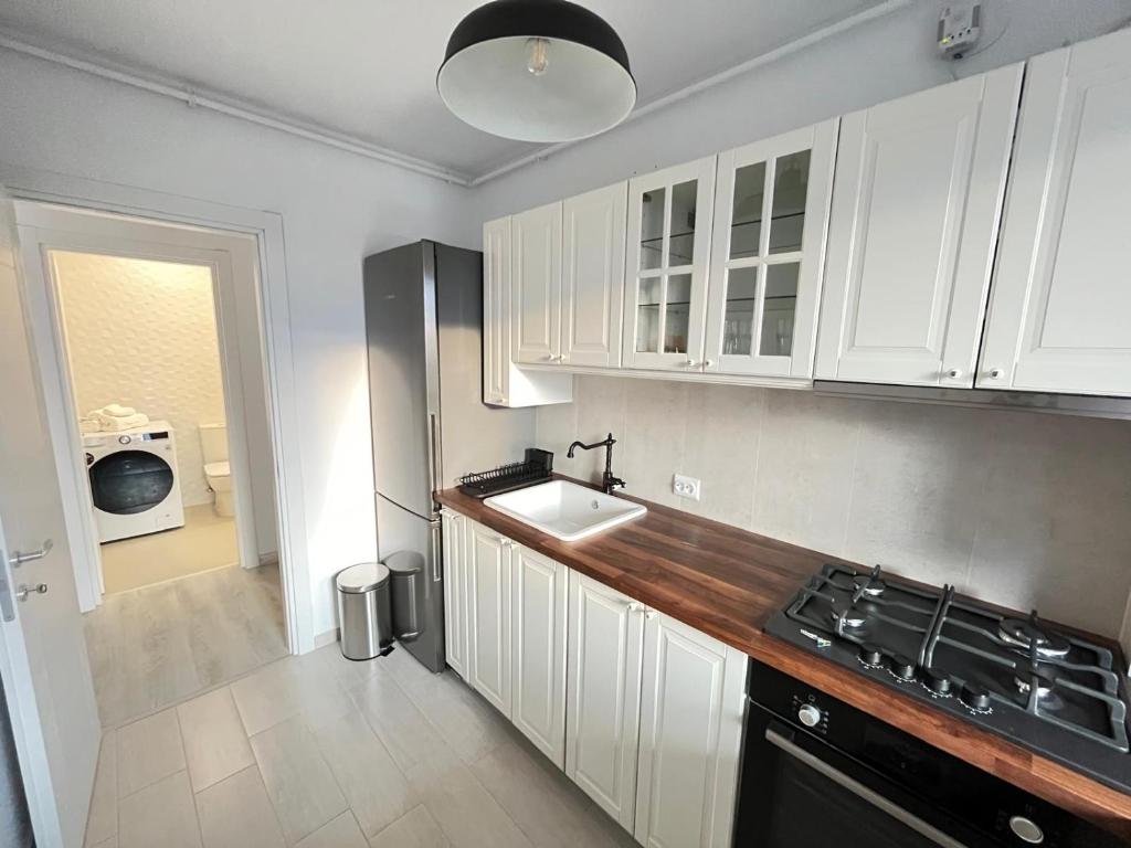 Una cocina con gabinetes blancos y un fregadero. en Hils Pallady - AMY Apartment, en Bucarest