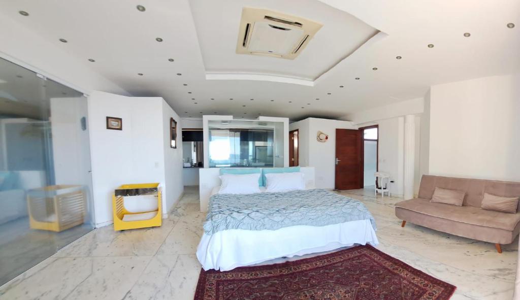 ein großes Schlafzimmer mit einem Bett und einer Couch in der Unterkunft Villa Romana Búzios in Búzios