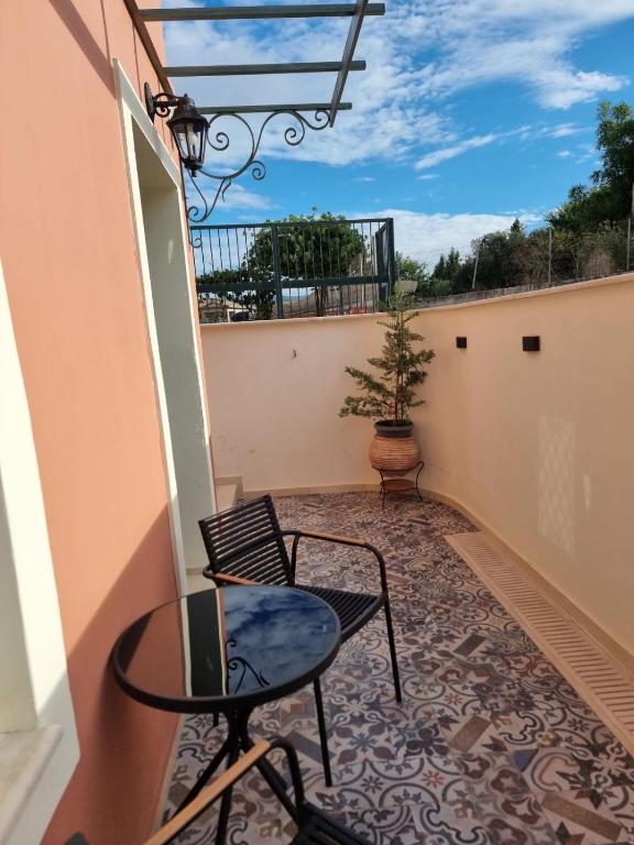 a balcony with a table and chairs and a potted plant at Corfusion studio in Alykes Potamou