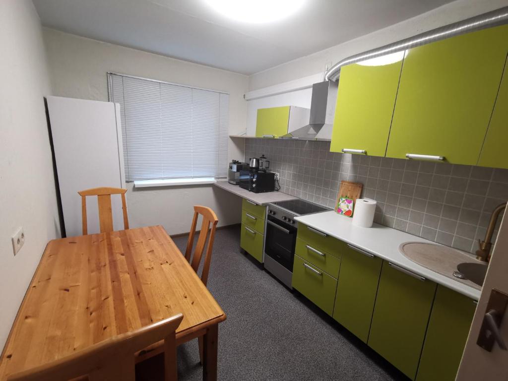 a kitchen with green cabinets and a wooden table at Peipsi Mehikoorma korter in Mehikoorma
