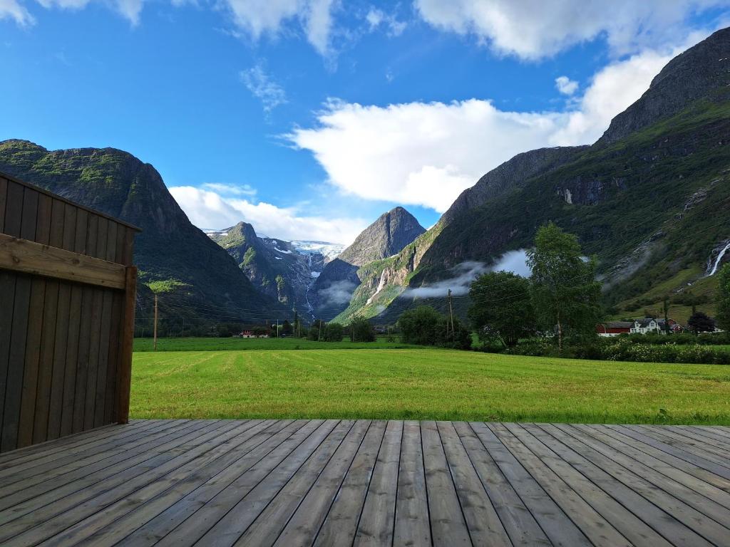 a wooden deck with mountains in the background at Microen in Stryn