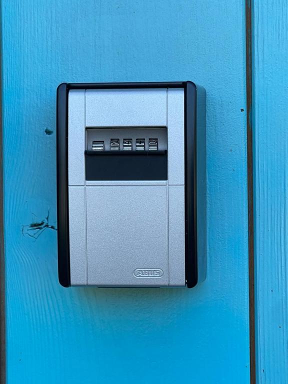 un forno a microonde appeso a una parete blu di Uniek Tiny house nabij de kust in mooie polders a Zuienkerke