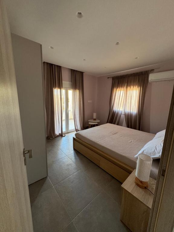 a bedroom with a large bed and a window at PUERTO VILLA, Best Location in Porto Rafti in Porto Rafti