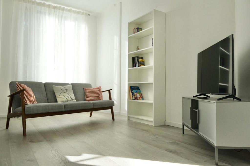 un salon avec un canapé et une télévision à écran plat dans l'établissement T3 climatisé vue rade et Mont Faron, calme à la Corniche, à Toulon