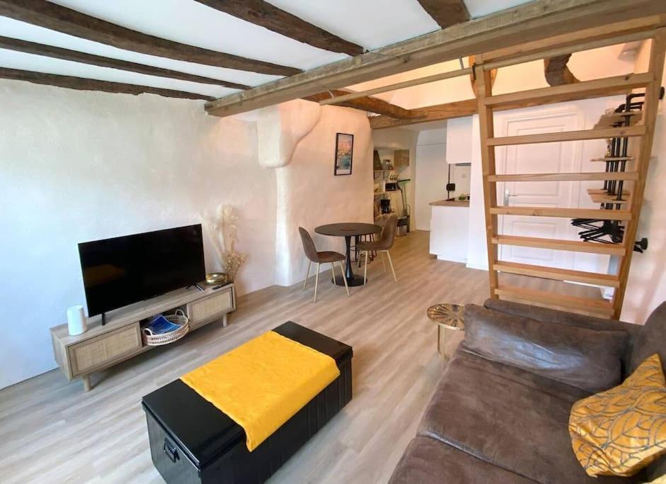 a living room with a couch and a tv at Morlaix Hyper Centre Charme in Morlaix