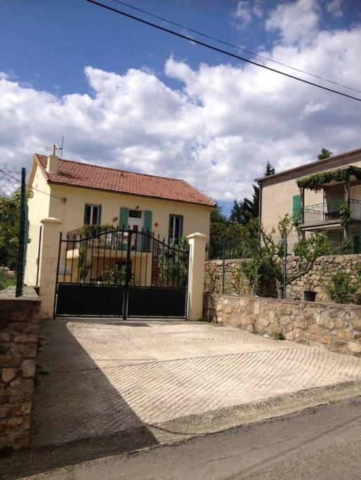 une maison blanche avec une porte noire devant dans l'établissement Maison de la cigale enchantée, à La GrandʼCombe