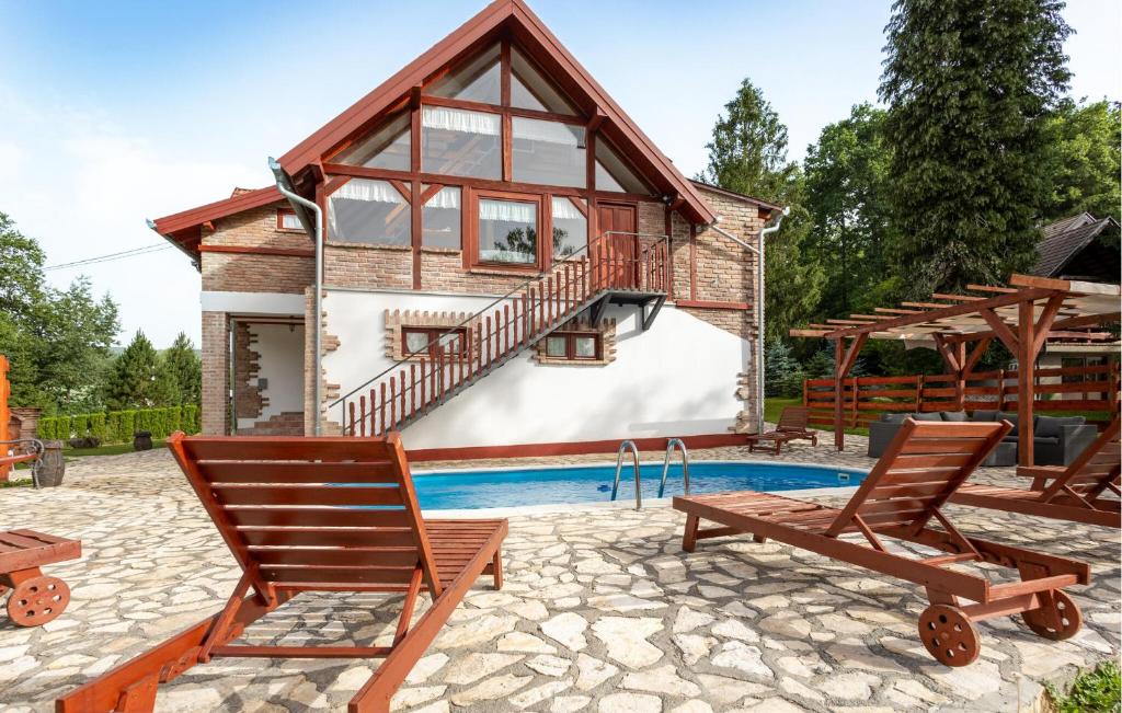 a house with a swimming pool and two chairs at Awesome Home In Novo Zvecevo With Sauna in Novo Zvecevo