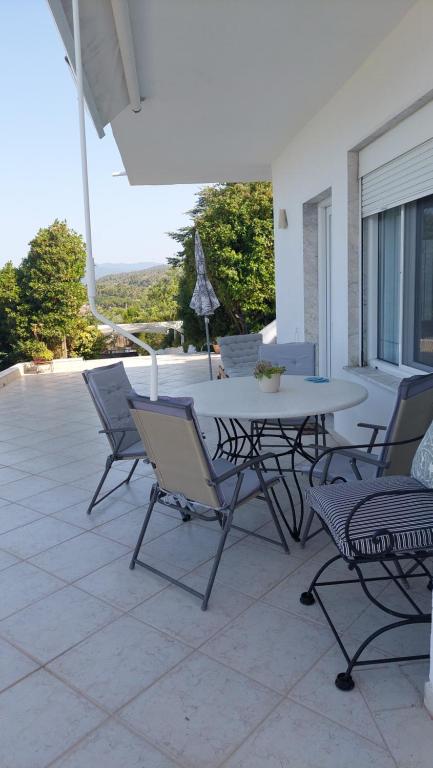 a patio with a table and chairs on a patio at Seaview dreams in Ormos Panagias