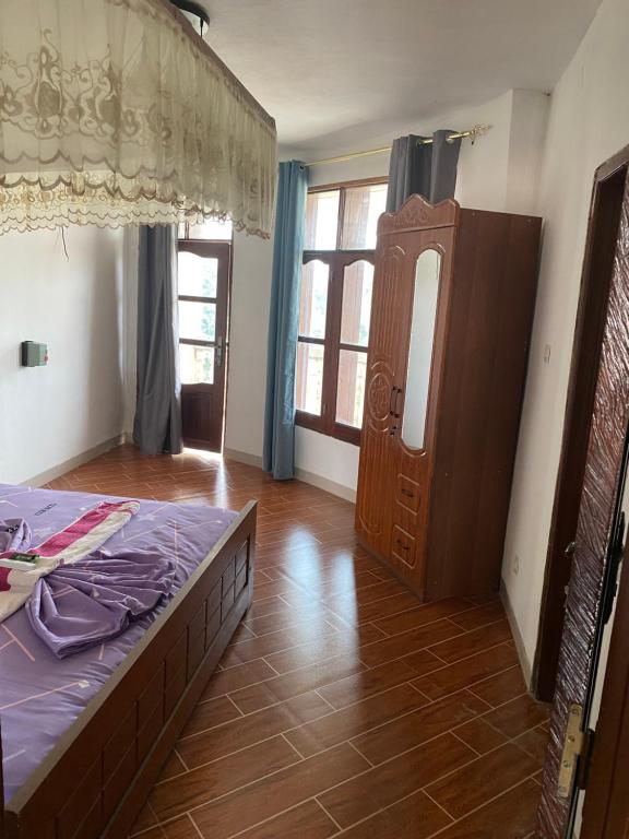 a bedroom with a bed and a dresser and a mirror at Hotel new plazza in Kisangani