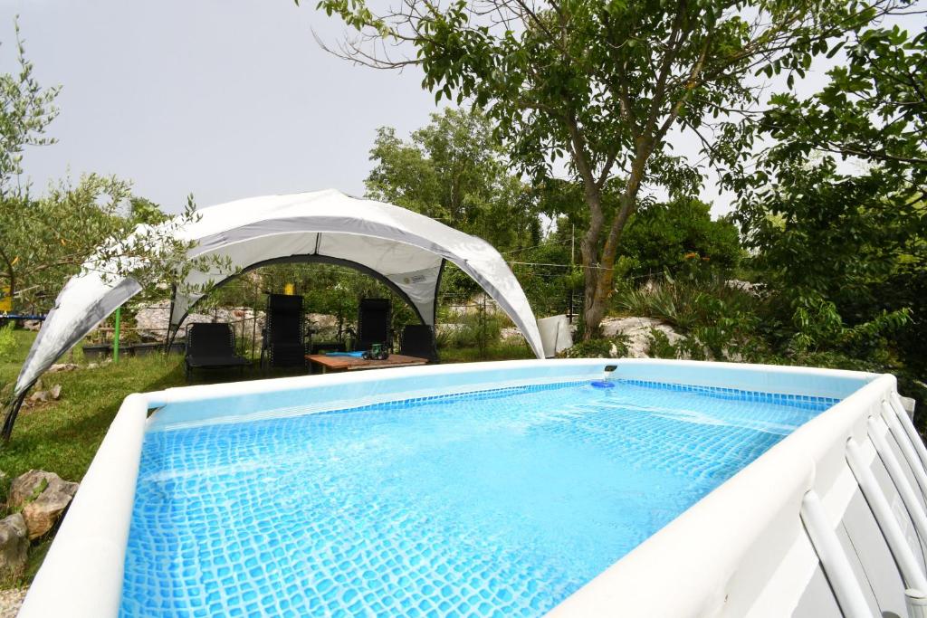 a swimming pool in a yard with a white tent at House Gioia Cristina in Labin