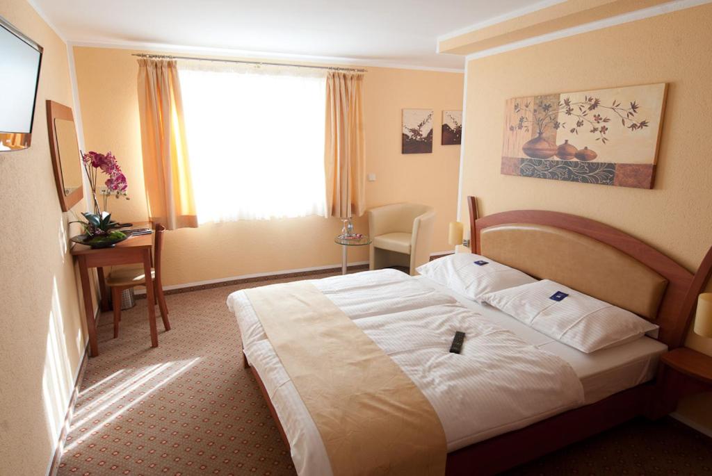 um quarto de hotel com uma cama e uma janela em Aristo Hotel em Filderstadt