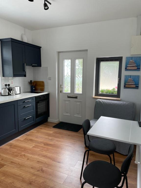 a kitchen with a table and two chairs and a table at Marta Studio Apartment in Ennistymon