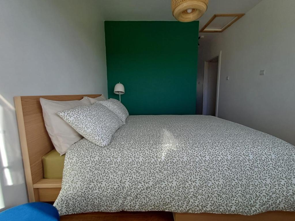 a bedroom with a large bed with a green wall at Marta Studio Apartment in Ennistymon