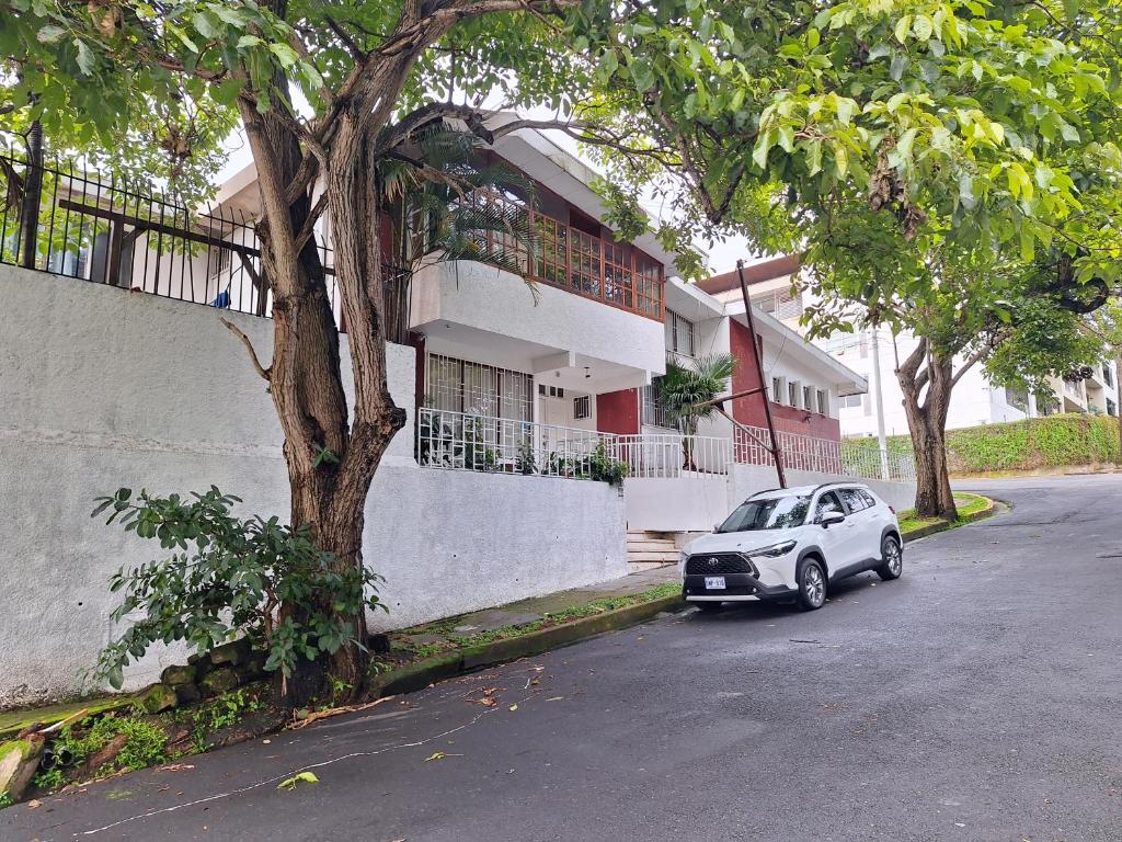 a small car parked in front of a house at Carolina Hostel in San José