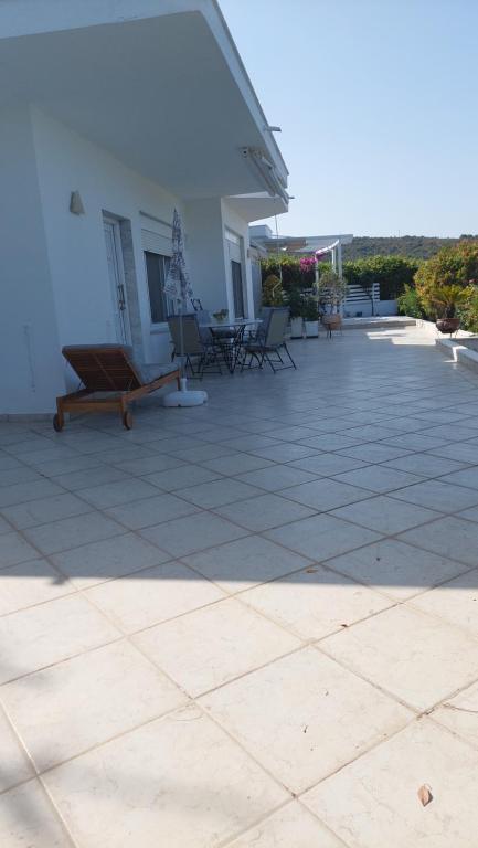 a patio with chairs and a white building at Seaview dreams in Ormos Panagias