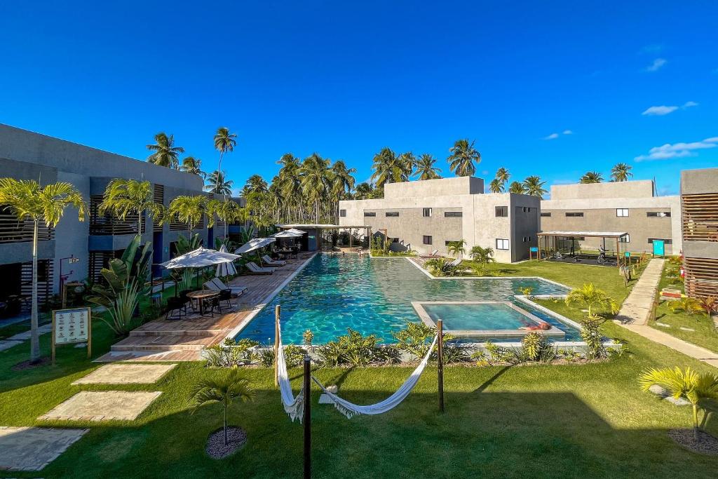 einen Pool mit Hängematte vor einem Gebäude in der Unterkunft Villa Manatee Rota dos Milagres in Tatuamunha