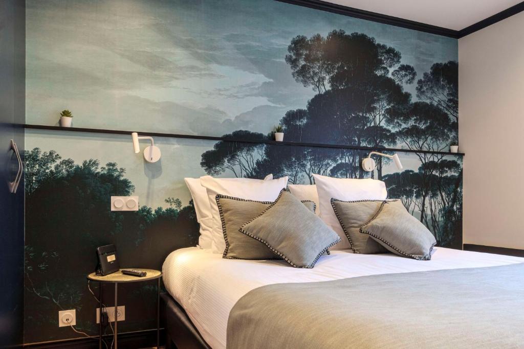 a bedroom with a bed with a large painting on the wall at Best Western Les Bains Hotel et SPA in Perros-Guirec