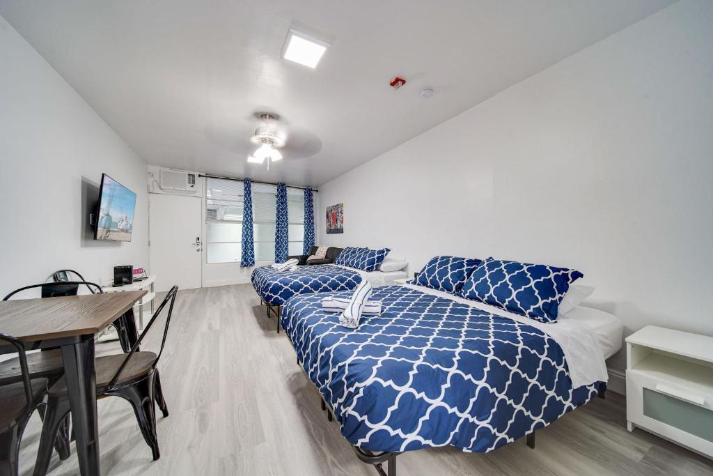 a bedroom with two beds and a table and a desk at Deco Beachside Apt, w/2 Queen Beds, Washer/Dryer in Miami Beach