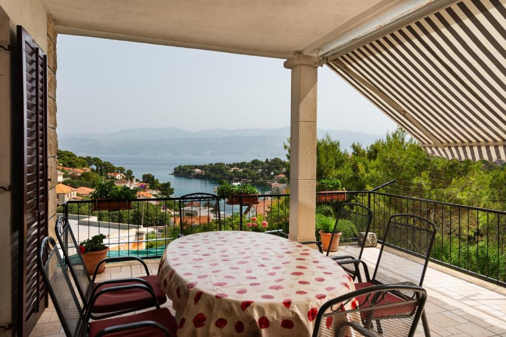 a table and chairs on a balcony with a view of the water at Apartments with parking space Splitska, Brac - 2867 in Splitska